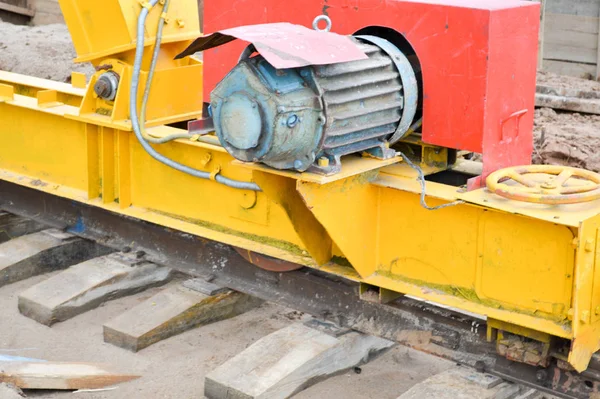 Logam besi besar pendukung kuning pada rel dengan roda dengan motor induksi dari konstruksi besar stasioner industri kuat derek gantry dari jenis jembatan — Stok Foto