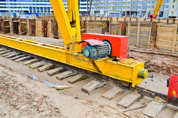 Logam besi besar pendukung kuning pada rel dengan roda dengan motor induksi dari konstruksi besar stasioner industri kuat derek gantry dari jenis jembatan — Stok Foto