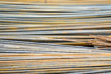 Güçlendirilmiş betondan yapılmış binaların yapımında kullanılan katmanlı takviyelerden elde edilen demir metal, paslı sarı çubuklar. Doku, arkaplan