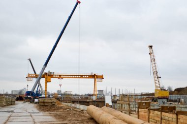 Metropolis 'in büyük bir şehrinde metro istasyonunun modern bir hattının inşası sırasında uzman profesyonel ekipman ve vinçlere sahip bir inşaat alanı.