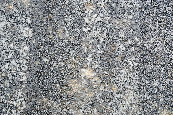 Gray asphalt road with small pebbles and cracks. Texture, background — Stock Photo, Image