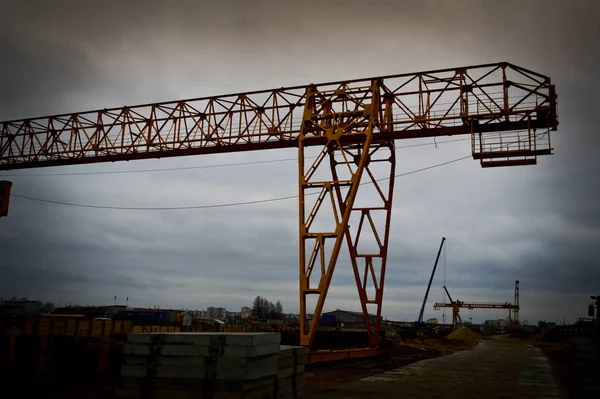 Hohe schwere gelb metallene Eisen tragende Konstruktion stationäre leistungsstarke Portalkran von Brückentyp auf Stützen für das Heben von Fracht auf einer modernen Baustelle von Gebäuden und Häusern — Stockfoto