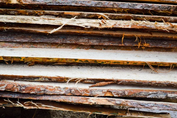 Viele lange naturgehobelte Holzbretter und Stöcke an einem Sägewerk. Die Vorgeschichte. Textur. Konzept: Holzernte für die Holzindustrie — Stockfoto