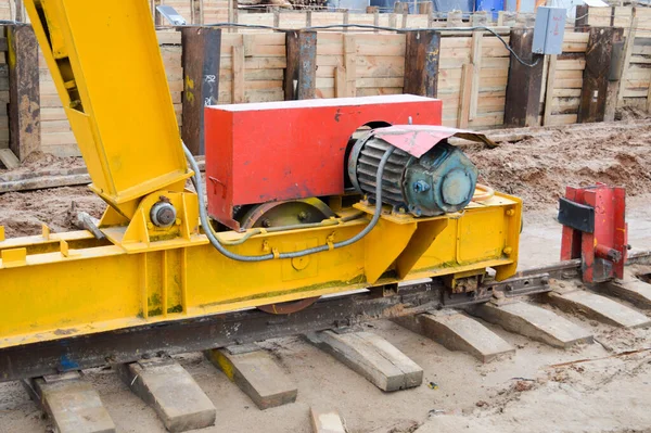 Grote ijzeren metalen gele steunen op rails met wielen met inductiemotor van een grote stationaire industriële krachtige portaalkraan van het brugtype — Stockfoto