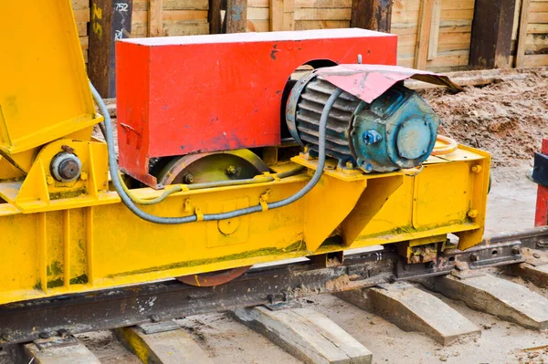 Grote ijzeren metalen gele steunen op rails met wielen met inductiemotor van een grote stationaire industriële krachtige portaalkraan van het brugtype — Stockfoto