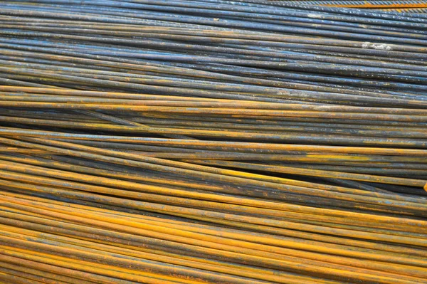 Vas fém rozsdás sárga rúd ipari épület megerősítése hullámosított megerősítés az épületek építéséhez készült vasbeton. textúra, háttér — Stock Fotó