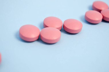 Hastalıkların tedavisi için kırmızı yuvarlak tıbbi ilaçlar mavi arka planda haplar.