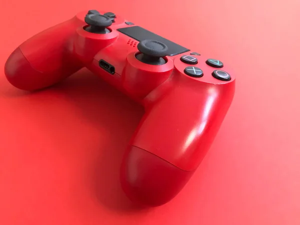 Beautiful red digital modern new game joystick for computer video games gamepad on a red background — Stock Photo, Image