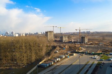 Vinçleri ve binaları olan büyük bir inşaat alanının üst manzarası metropolün büyük şehrinin beton monolitik çerçeve paneli çok katlı gökdelenleri