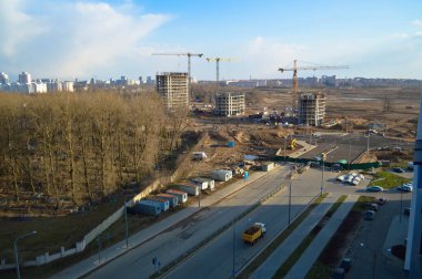 Vinçleri ve binaları olan büyük bir inşaat alanının üst manzarası metropolün büyük şehrinin beton monolitik çerçeve paneli çok katlı gökdelenleri