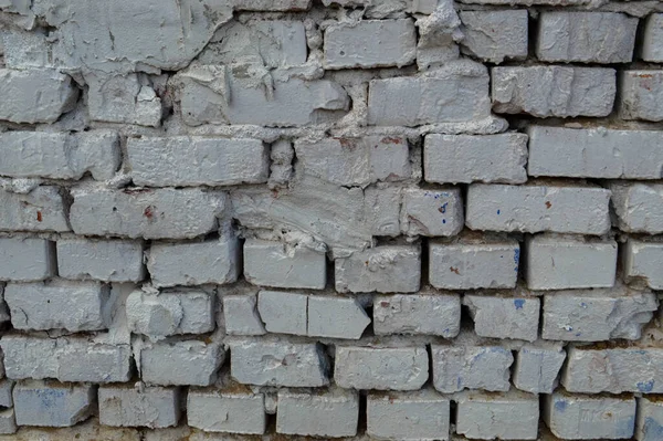 Güzel beyaz boyanmış tuğla duvar eski püskü, çatal çatallı ve dikişli. Doku, arkaplan