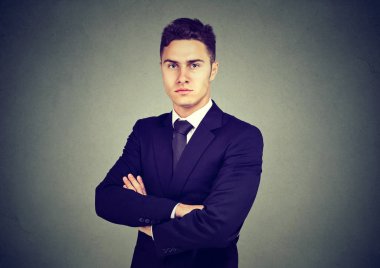 Gri arka plan üzerinde izole kendine güvenen genç işadamı portresi 