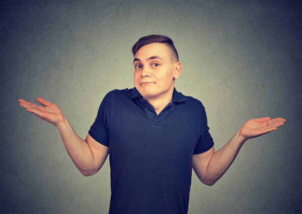 Ignorance. Man shrugging shoulders who cares so what isolated on gray background. 