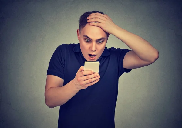 Hombre sorprendido mirando su teléfono móvil viendo malas noticias leyendo mensaje de texto — Foto de Stock