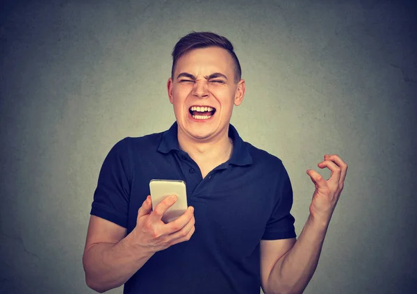Злий чоловік кричить на свій мобільний телефон, розлючений поганою службою поганої якості смартфона — стокове фото