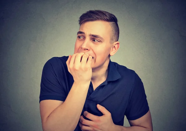 Angstig aarzelend man zijn nagels te bijten — Stockfoto