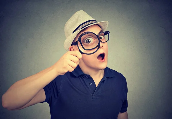 Surprised investigator looking through magnifying glass — Stock Photo, Image