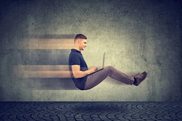 Conceito de internet rápida. Levitando homem de negócios na estrada usando laptop — Fotografia de Stock