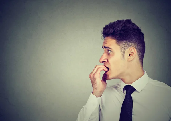Preoccupied anxious man biting his fingernails looking to the side — Stock Photo, Image