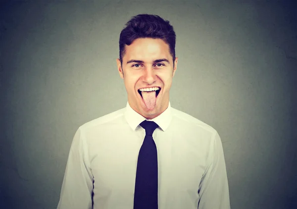 Retrato de un hombre guapo mostrando su lengua — Foto de Stock