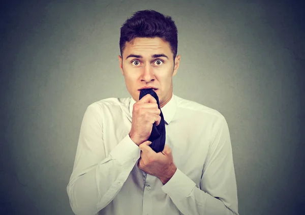 Hombre de negocios ansioso masticando nerviosamente su corbata mirando a la cámara — Foto de Stock