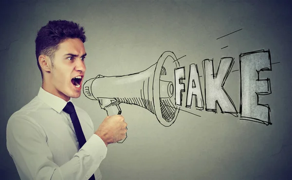 Homem de negócios irritado gritando em um megafone espalhando notícias falsas — Fotografia de Stock