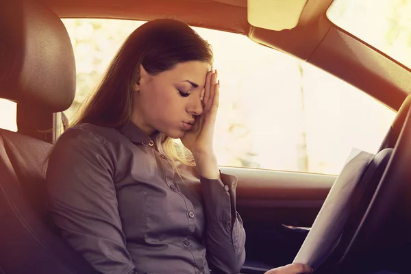 Vrouw stuurprogramma benadrukt met papieren zit in haar auto — Stockfoto