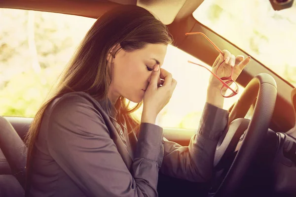 Kobieta o ból głowy, zdejmując okulary ma do zatrzyma się po samochód do jazdy w korku — Zdjęcie stockowe
