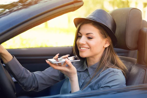 Happy woman sitting inside convertible car using a smart phone voice recognition function on line — Stock Photo, Image