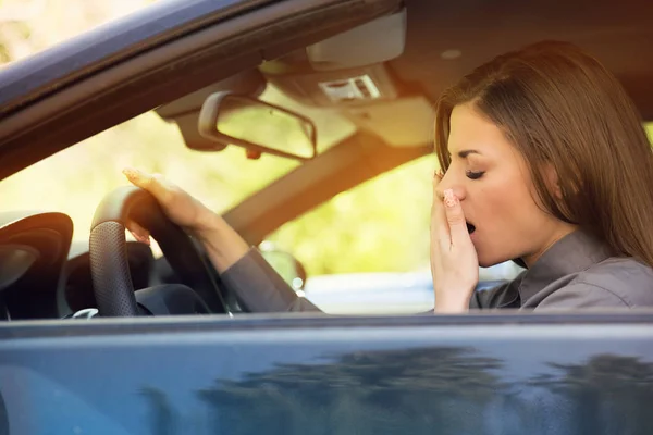 Soñoliento fatigado bostezando joven mujer conducir su coche —  Fotos de Stock