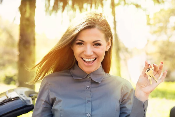 Mujer feliz sosteniendo dando llaves que muestran — Foto de Stock