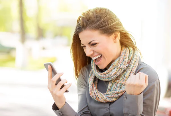 Opgewonden student lezen goed nieuws op mobiele telefoon buitenshuis verschikbaar — Stockfoto