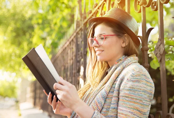 Mujer joven leyendo un libro al aire libre — Foto de Stock