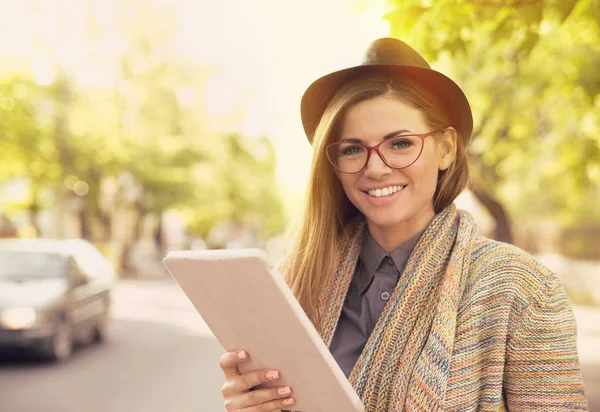 Lycklig kvinna i glas med tablet PC i en stad — Stockfoto