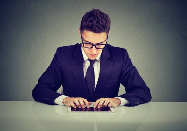 Yakışıklı işadamı masa başında çalışırken bir tablet bilgisayar kullanarak  