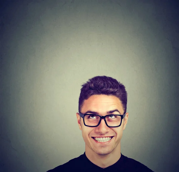 Schöner glücklicher junger Mann mit Brille, der nach oben schaut — Stockfoto