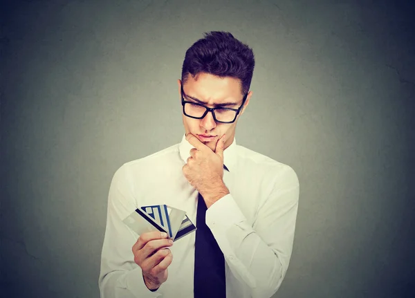 Homem pensativo com muitos cartões de desconto de fidelidade de crédito diferentes — Fotografia de Stock