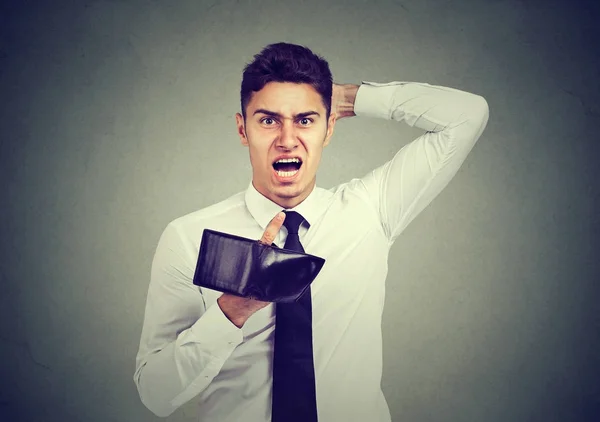 Sorprendido, frustrado hombre enojado, sosteniendo una cartera vacía — Foto de Stock