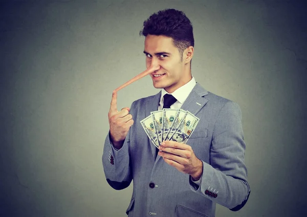 Financiële fraude concept. Sly leugenaar jonge zakenman met dollar cash — Stockfoto