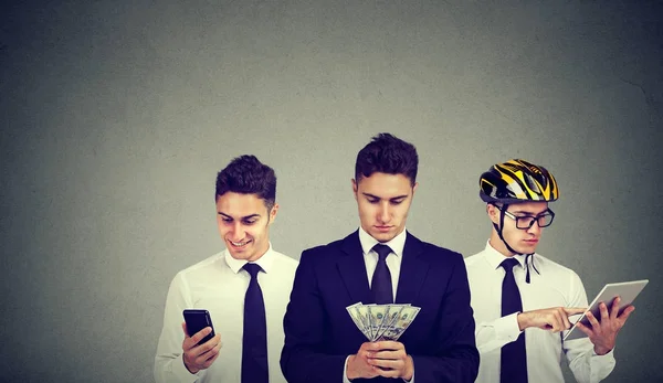 Joven hombre de negocios multitarea usando la tableta del teléfono móvil contando dinero — Foto de Stock