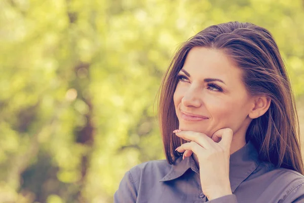 Portrait of a happy woman in park on sunny autumn afternoon. Cheerful beautiful girl in gray shirt and outdoors on beautiful fall day. — Stock Photo, Image