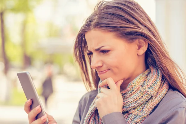 Closeup portret verdrietig, sceptisch, ongelukkig, vrouw texting op telefoon ontevreden over gesprek geïsoleerd buiten achtergrond. — Stockfoto