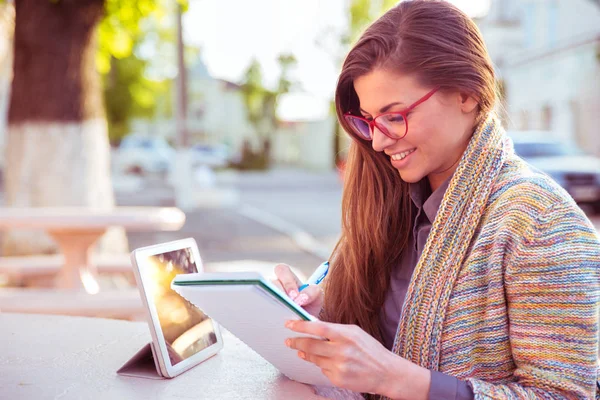 Šťastná mladá žena s tužkou v pracovní notebook venkovní — Stock fotografie