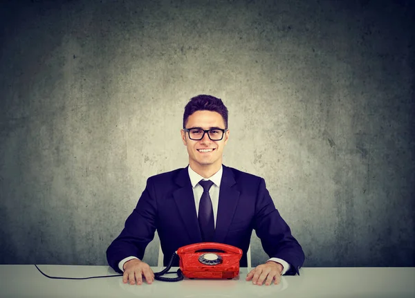 Knappe jonge zakenman zit aan bureau met vintage land telefoonlijn — Stockfoto