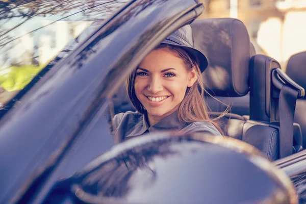 Happy young woman driving convertible on a sunny autumn day — Stock Photo, Image