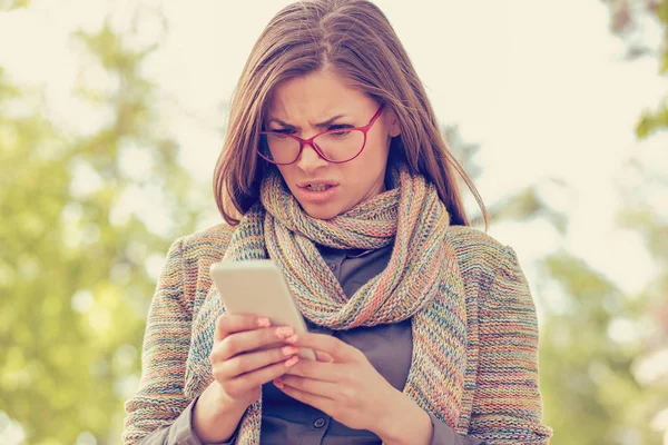 Giovane donna che guarda arrabbiato al telefono — Foto Stock