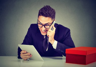 Tablet bilgisayar kullanarak telefon üzerinden online sipariş heyecanlı genç adam 