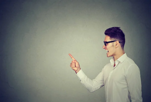 Hombre alegre mostrando dirección y señalando con el dedo — Foto de Stock