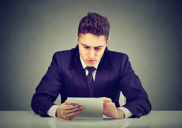 Retrato de un joven hombre de negocios usando una tableta PC sentado en la mesa —  Fotos de Stock