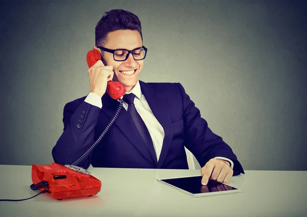 Щасливий бізнесмен, використовуючи планшетний комп'ютер, розмовляє по телефону — стокове фото